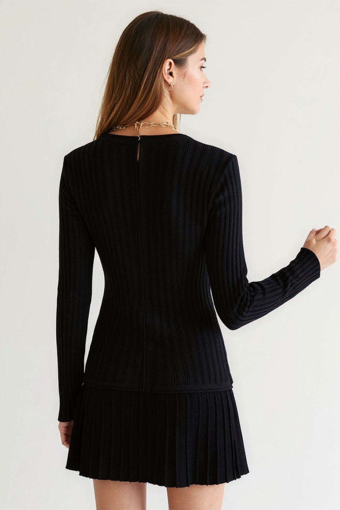 Completo due pezzi in maglia a costine con cardigan e minigonna plissettata