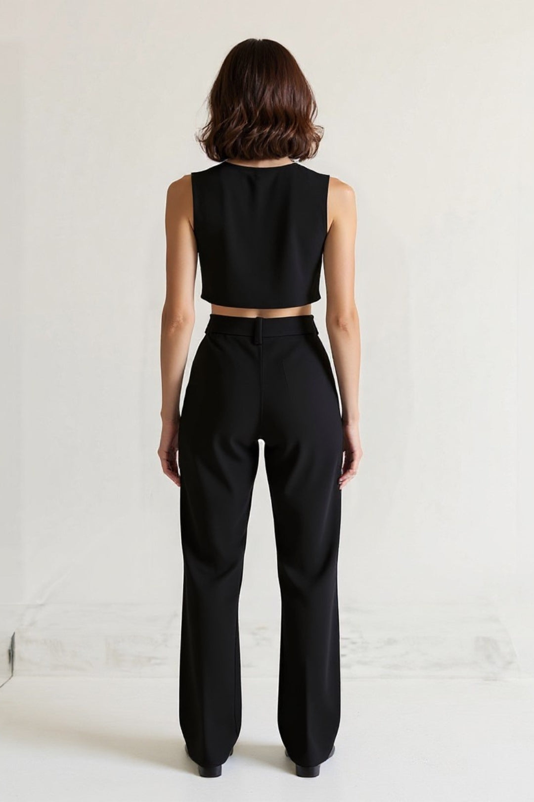 Completo elegante in due pezzi con top corto senza maniche e pantaloni a vita alta neri