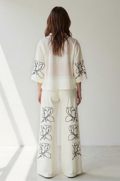 Completo in tessuto leggero con camicia ampia e pantaloni a gamba larga con stampa floreale | Bianco con fiori neri | Elegante e fresco