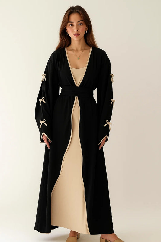 Completo lungo in due pezzi con abito beige e soprabito nero con fiocchi decorativi