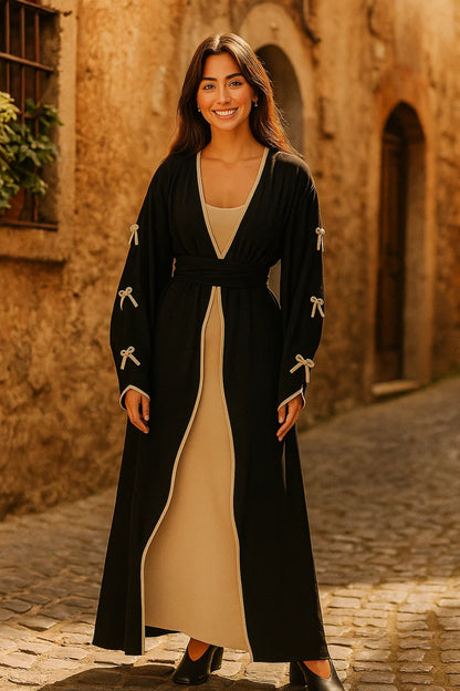 Completo lungo in due pezzi con abito beige e soprabito nero con fiocchi decorativi
